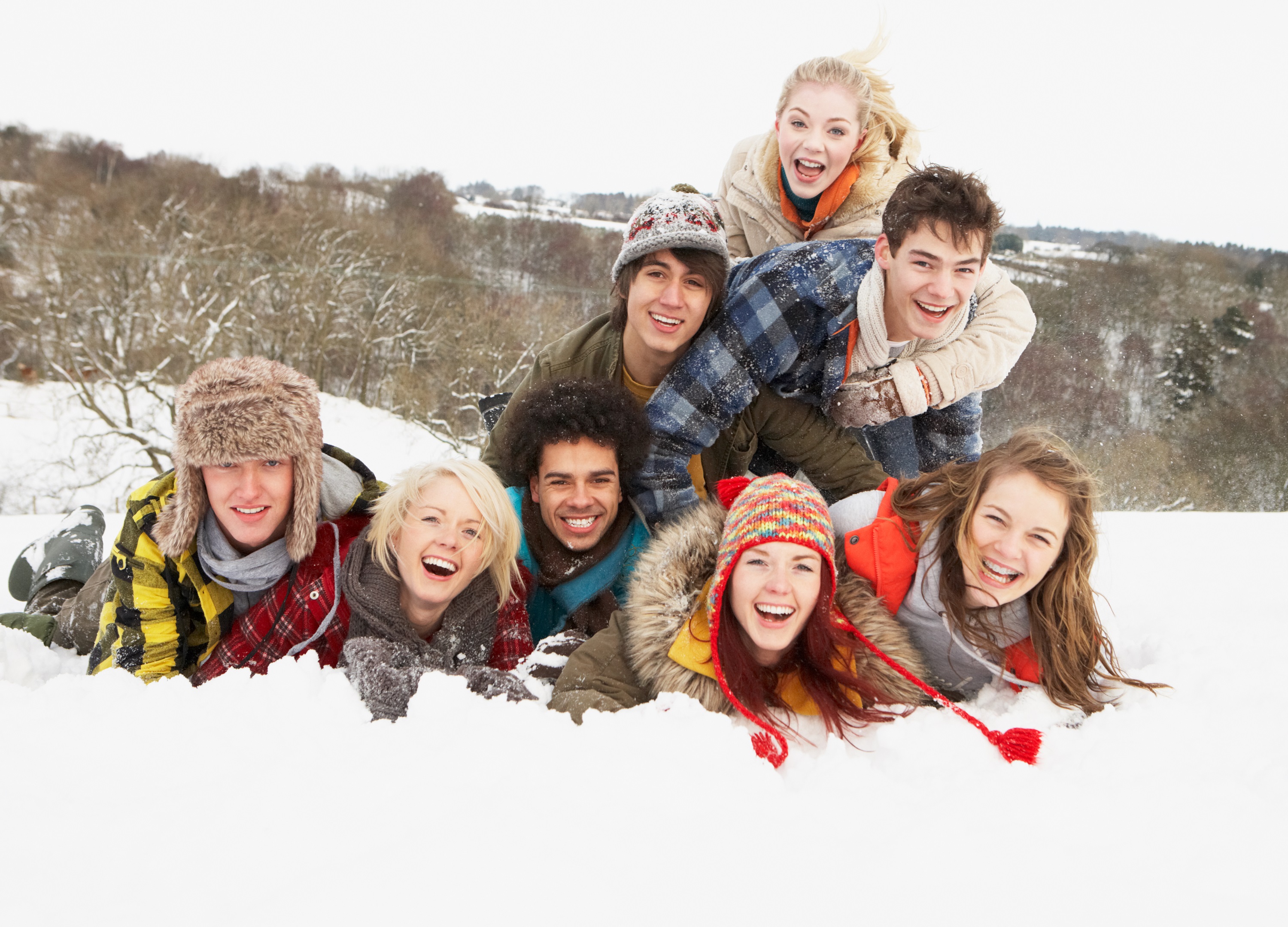 group of smiling young teens in the snow